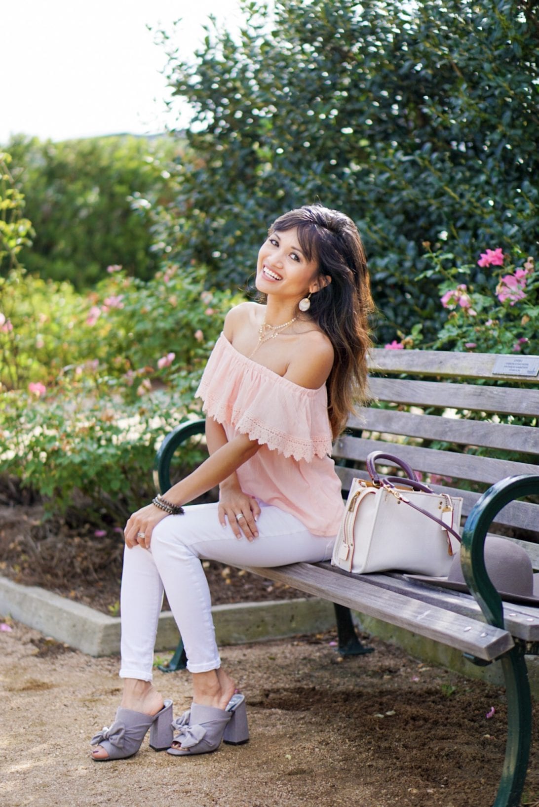 peach off the shoulder top, white jeans, coach rogue bag, gray mules, rose garden