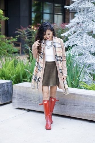 hunter boots, hunter boots outfit, holiday outfits, how to wear hunter boots, christmas outfits with hunter boots, gift guide for her, red hunter boots, hunter boots for the holidays, plaid scarf, monogrammed scarf, camel coat, corduroy skirt, bauble bar necklace