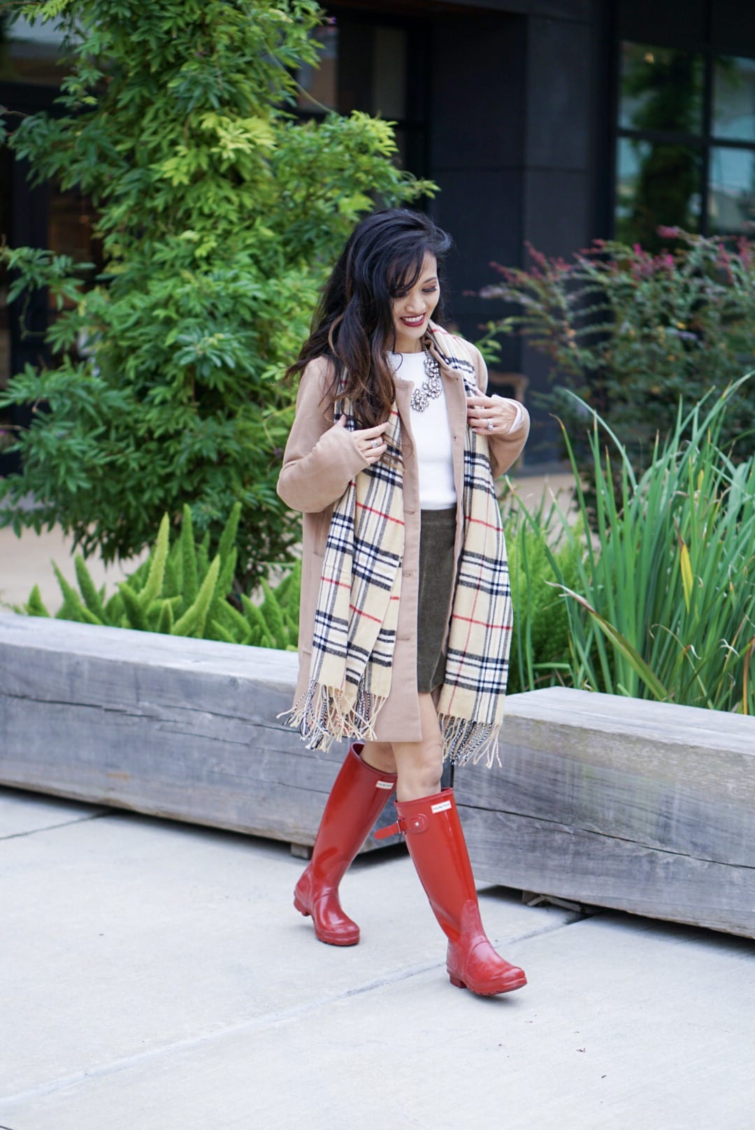 hunter boots, hunter boots outfit, holiday outfits, how to wear hunter boots, christmas outfits with hunter boots, gift guide for her, red hunter boots, hunter boots for the holidays, plaid scarf, monogrammed scarf, camel coat, corduroy skirt, bauble bar necklace, Kendra Scott red Danielle earrings