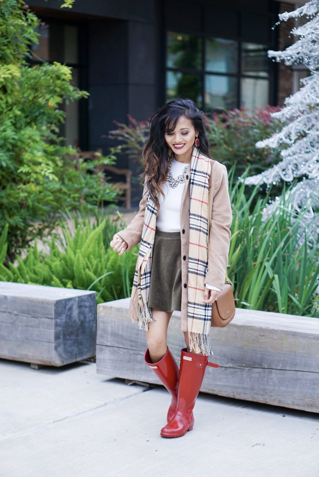 hunter boots, hunter boots outfit, holiday outfits, how to wear hunter boots, christmas outfits with hunter boots, gift guide for her, red hunter boots, hunter boots for the holidays, plaid scarf, monogrammed scarf, camel coat, corduroy skirt, bauble bar necklace 