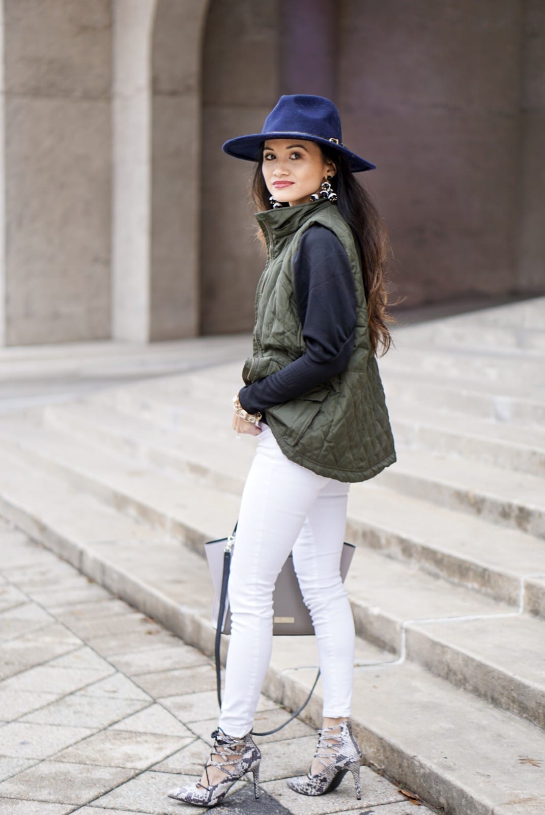 utility vest, green vest, Zac Posen bag, white jeans, white denim outfit, lace up heels, navy felt brim hat, red dress boutique, puff sleeves, bauble bar earrings, statement earrings, how to wear a vest, winter outfit, how to style a hat 