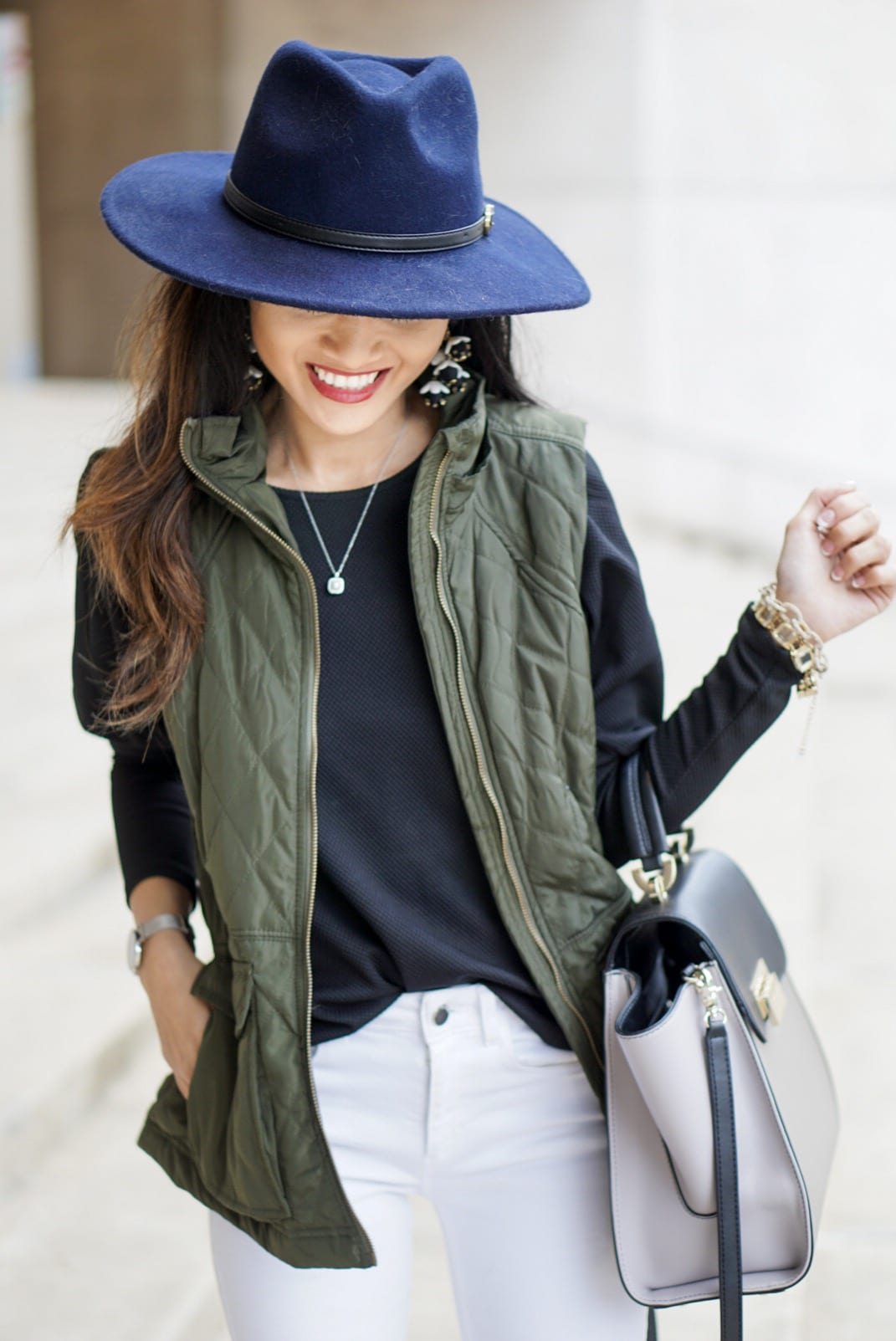 utility vest, green vest, Zac Posen bag, white jeans, white denim outfit, lace up heels, navy felt brim hat, red dress boutique, puff sleeves, bauble bar earrings, statement earrings, how to wear a vest, winter outfit, how to style a hat 