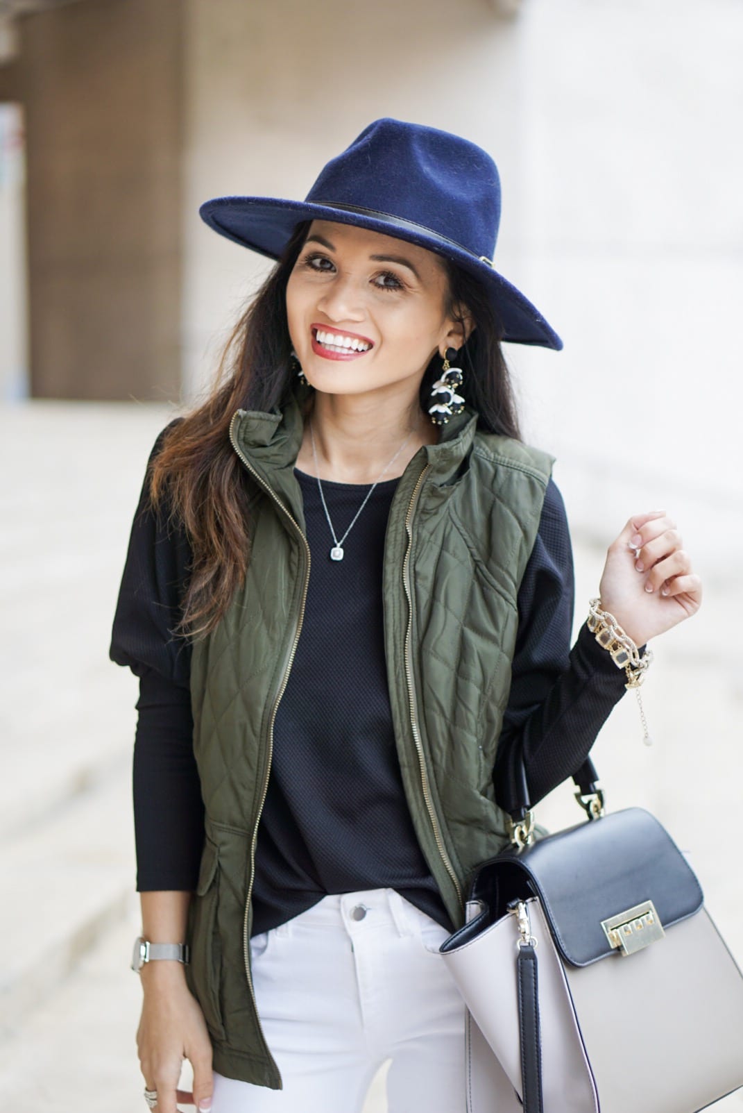 utility vest, green vest, Zac Posen bag, white jeans, white denim outfit, lace up heels, navy felt brim hat, red dress boutique, puff sleeves, bauble bar earrings, statement earrings, how to wear a vest, winter outfit, how to style a hat 