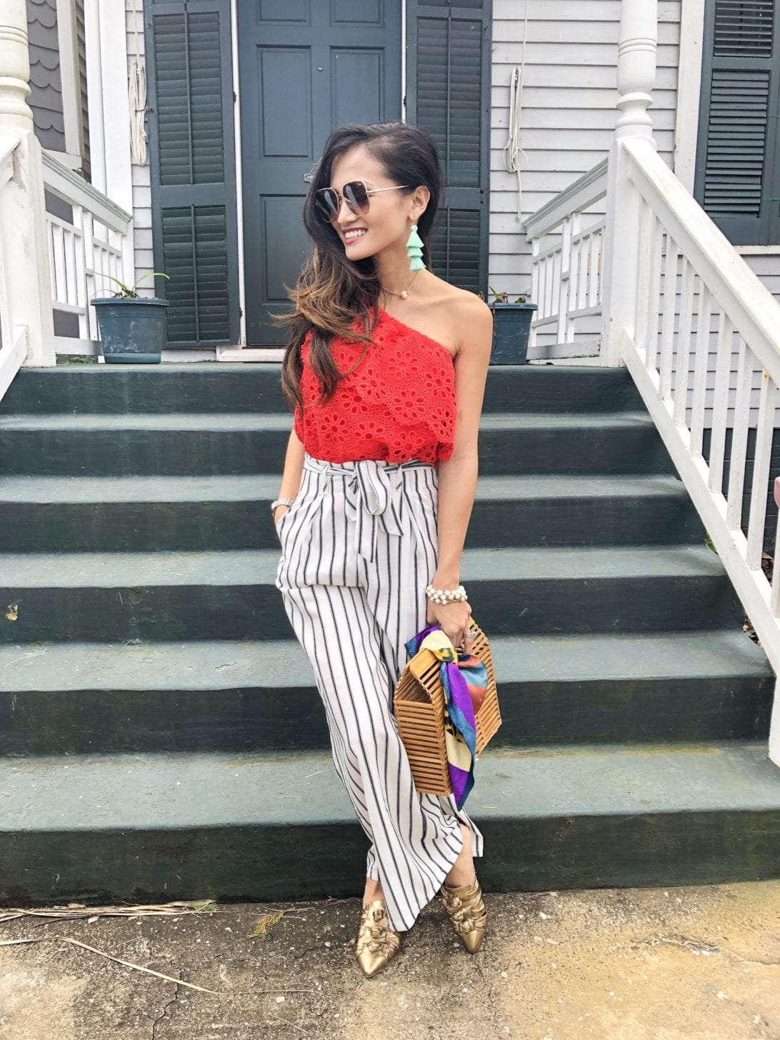 Jack by BB Dakota Lolita Top, striped pants, wide leg culottes, bamboo bag, quay sunglasses, one shoulder top, eyelet top, spring style, spring outfit, spring fashion, Rebecca Minkoff slides, Rebecca Minkoff Aden Slides, accessories for spring, tassel earrings 