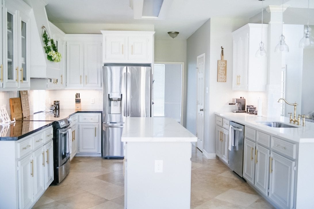 gold and white kitchen, kitchen island, subway tiles, contrasting countertops and cabinets 