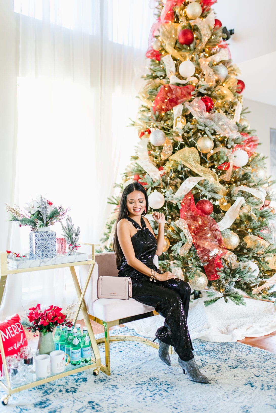 two story living room, Christmas style, red and gold Christmas tree, sequin jumpsuit 