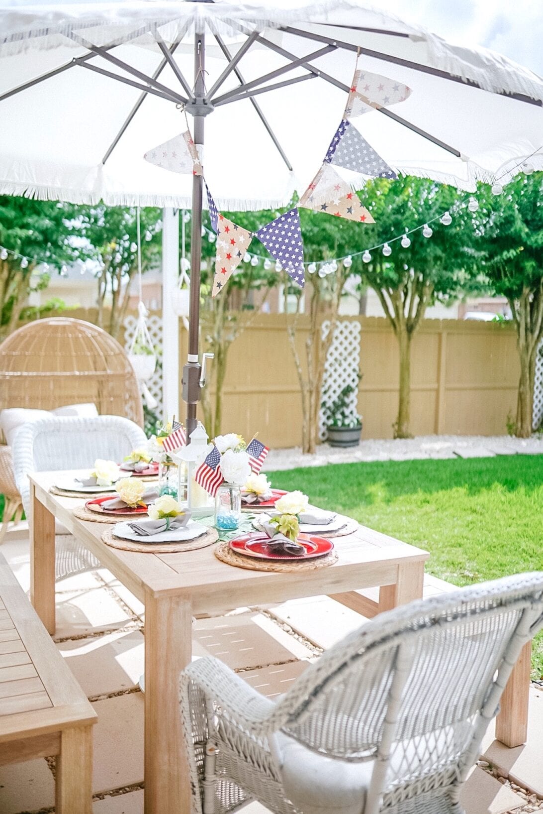 patriotic themed tablescape, patio furniture, fringe umbrella, solar string lights 