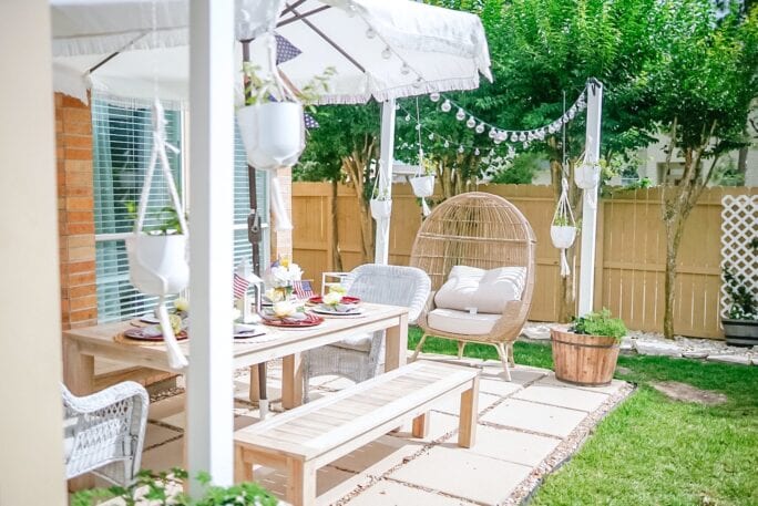 outdoor patio, patio diy, patio makeover, egg chair, whiskey barrel planters, whiskey barrel lantern post, string lights 