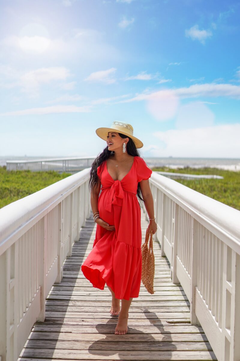 bump friendly summer red dress, red dress, Memorial Day outfit, straw hat, woven bag, pregnancy style, summer pregnancy outfit, bump style, mom earrings 